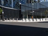 a large building with a glass and steel structure on top of it by a street