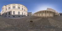 a panoramic view of a building and a fire hydrant outside it, with the reflection of the sphere in the center