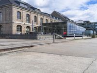 red suitcases are on the sidewalk in front of a glass building with stairs and other stairs