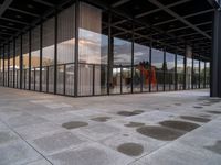 a person standing outside a building in a large area of cement and concrete tiles, with multiple circles