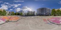 a 360 - panorama image of graffiti in an urban setting, with trees on the ground and buildings behind