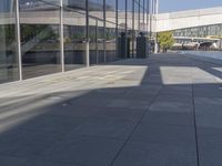 a man riding a skateboard next to glass windows on the sidewalk outside a building