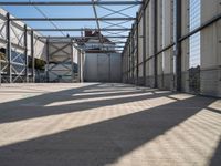 a walkway through an unfinished building with windows and metal construction on either side of it