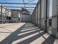 a walkway through an unfinished building with windows and metal construction on either side of it