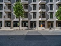 large building with a lot of windows along side of street with two bicycles on it