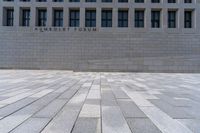 an empty courtyard with a stone block wall and a blue sky in the background that reads humboldt forum