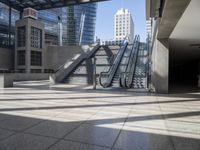 a building with escalators in the background of skyscrapers and windows in it