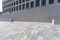 the large stone sidewalk is next to the building where it is housed as the hummellot forum