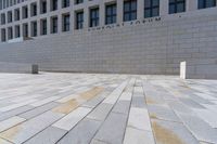 the large stone sidewalk is next to the building where it is housed as the hummellot forum