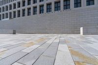 the large stone sidewalk is next to the building where it is housed as the hummellot forum