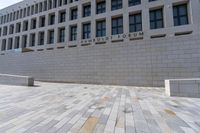 the large stone sidewalk is next to the building where it is housed as the hummellot forum