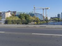 the city is behind a fence on a sunny day at the edge of a river