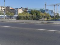 the city is behind a fence on a sunny day at the edge of a river