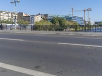 the city is behind a fence on a sunny day at the edge of a river