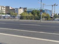 the city is behind a fence on a sunny day at the edge of a river