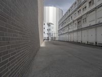 a street view from inside the building shows an empty alley, with several white buildings near the fence