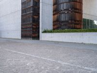 two wooden barrels are near some concrete buildings with bales on each side of them