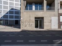 a sign on the side of a building with graffiti written on it in front of a building