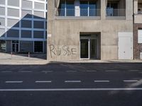 a sign on the side of a building with graffiti written on it in front of a building