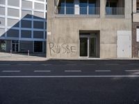 a sign on the side of a building with graffiti written on it in front of a building