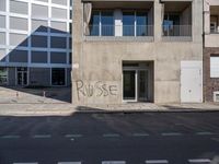 a sign on the side of a building with graffiti written on it in front of a building