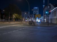 an empty street with bicycles sitting under the lights in front of some tall buildings by a street