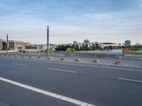 a highway is empty with some traffic lights and street signs in the foreground at an intersection