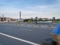 a highway is empty with some traffic lights and street signs in the foreground at an intersection