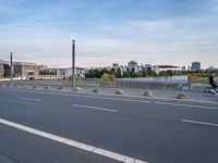 a highway is empty with some traffic lights and street signs in the foreground at an intersection