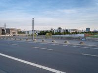 a highway is empty with some traffic lights and street signs in the foreground at an intersection