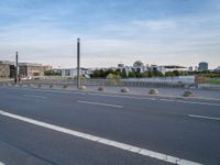 a highway is empty with some traffic lights and street signs in the foreground at an intersection