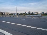 a highway is empty with some traffic lights and street signs in the foreground at an intersection