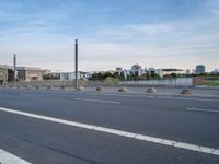 a highway is empty with some traffic lights and street signs in the foreground at an intersection