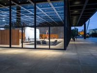 the view of an outdoor meeting room at night with large windows that can be open for people