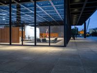 the view of an outdoor meeting room at night with large windows that can be open for people