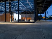 the view of an outdoor meeting room at night with large windows that can be open for people