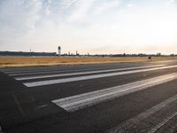 an empty runway with a cloudy sky above it and clouds in the background on the ground