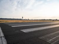 an empty runway with a cloudy sky above it and clouds in the background on the ground