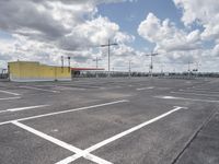 a parking lot with lots of empty parking spaces beneath cloudy skies and blue skies above