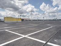 a parking lot with lots of empty parking spaces beneath cloudy skies and blue skies above