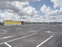 a parking lot with lots of empty parking spaces beneath cloudy skies and blue skies above