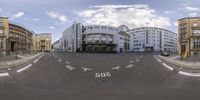 a panorama shows a street in front of several buildings with a sky background as well as two roads