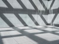 a room with some windows and shadows on the floor or floor to ceiling tiles in it