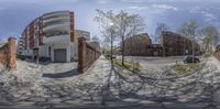 a fish eye lens is taking a photo of a paved area and buildings and a car