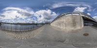 a fisheye photograph of an outdoor area near a river and bridge, taken with fisheye lens and the fish eye