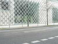 a person on a red motorcycle rides past a glass building on a city street in a city