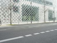 a person on a red motorcycle rides past a glass building on a city street in a city