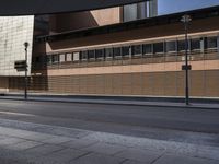 a empty city street and a tall wooden building behind it with windows, in an otherwise deserted urban setting