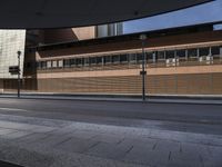 a empty city street and a tall wooden building behind it with windows, in an otherwise deserted urban setting