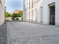 a small brick walkway in between two buildings with the door open and people walking on either side